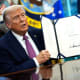 U.S. President Donald Trump holds up a signed act on Sept. 5, 2025, in the Oval Office of the White House.