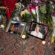 Lit candles and flowers rest by framed photos of mass shooting victims MukhammadAziz Amurzokov and Ella Cook at a memorial near Brown University.