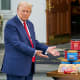 President Donald Trump gestures toward a table of groceries during a news conference.