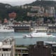 A coast guard ship sails through a body of water surrounded by a city.