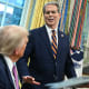 President trump, sitting-left, listens to Scott Bessent, standing-right, at the Oval Office.
