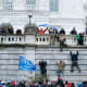 Trump supporters climb the west wall of the the Capitol
