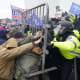 Police officers in yellow jackets and helmets push against Jan. 6 demonstrators near the U.S. Capitol.