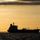 The silhouette of an oil tanker at sunrise.