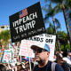A protester holds a sign reading "Impeach Trump" during a "Hands Off!" rally in on April 05, 2025 in Los Angeles.