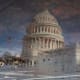 The Capitol is reflected in a puddle.