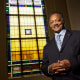 Rev. Jesse Jackson poses in front of a stained glass window.
