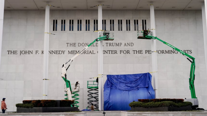 Workers affix signage adding President Donald Trump's name on the facade of the Kennedy Center in Washington, D.C.