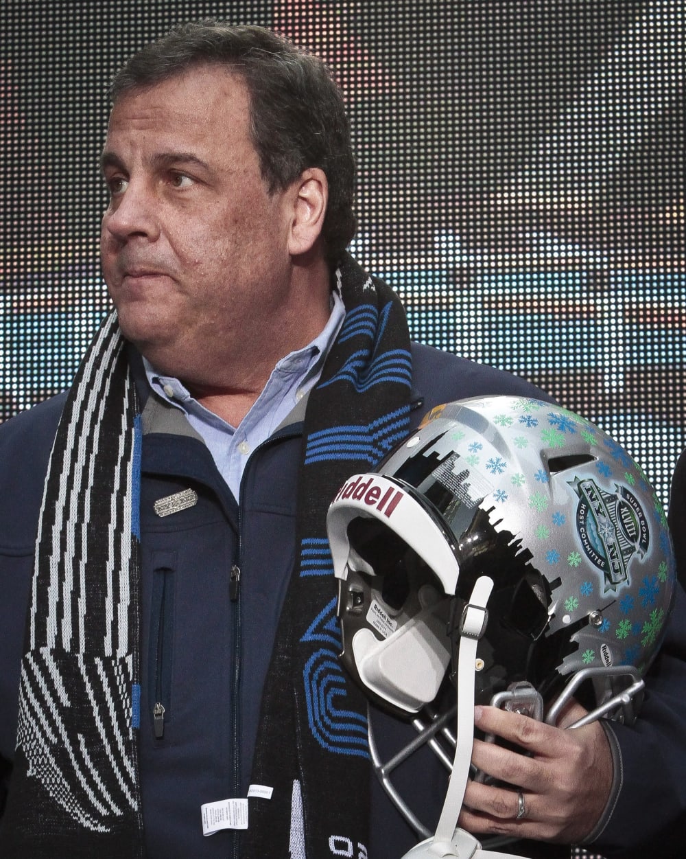 New Jersey Gov. Chris Christie holds a souvenir football helmet as he leaves after a ceremony to pass official hosting duties of next year's Super Bowl to representatives from Arizona, Saturday Feb. 1, 2014 in New York.