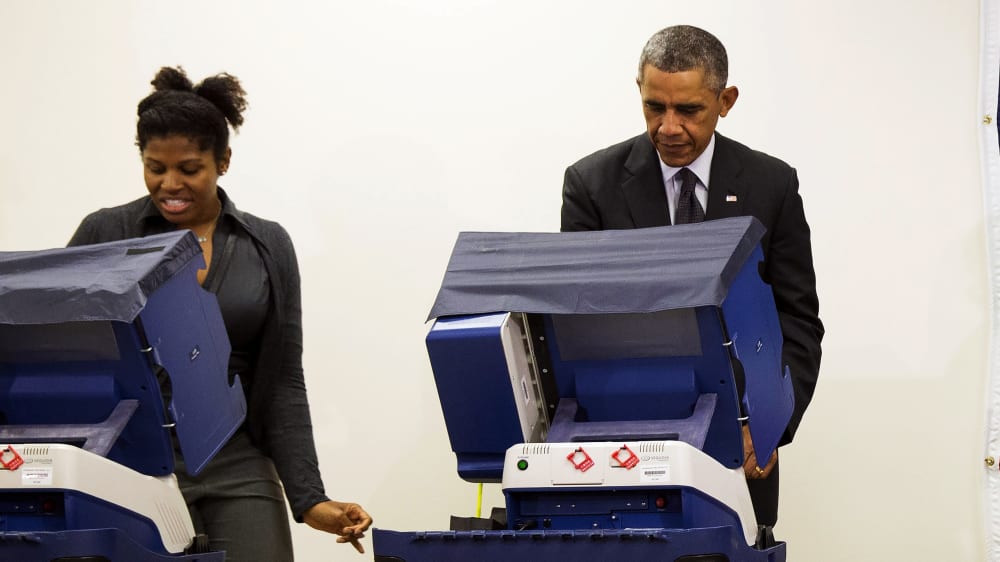 President Barack Obama votes next to Aia Cooper at the Dr. Martin Luther King Community Service Center in Chicago, Ill. on Oct. 20, 2014.