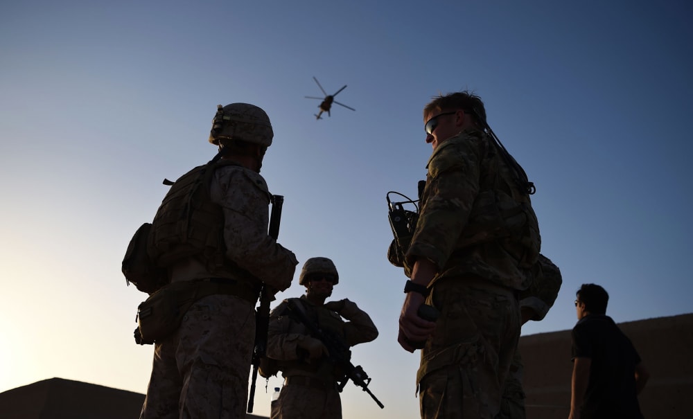 U.S. Marines and Afghan Commandos stand together as an Afghan Air Force helicopter flies past during a combat training exercise at Shorab Military Camp in Lashkar Gah in Helmand province, Afghanistan, on Aug. 27, 2017.