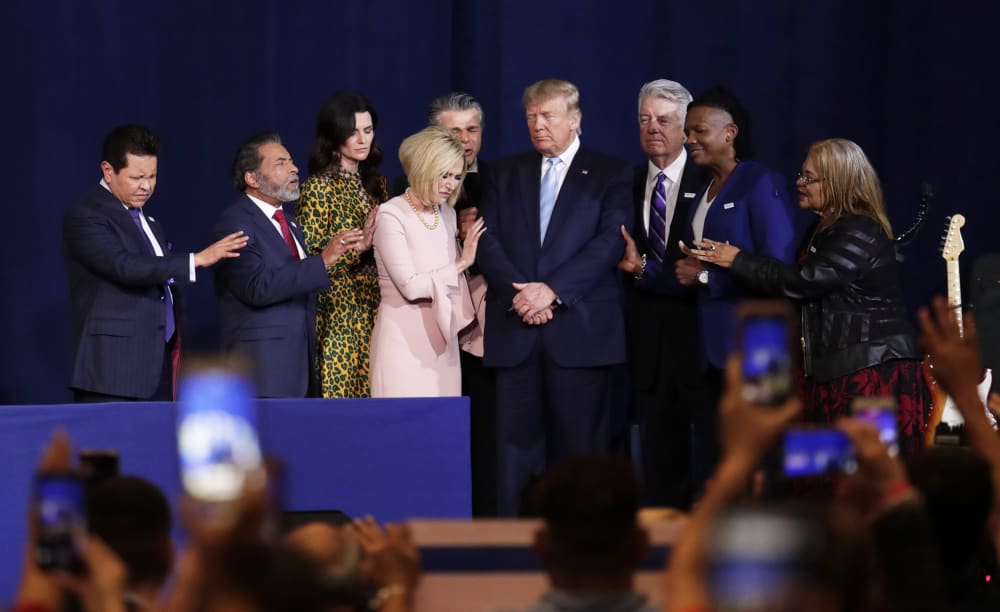 Pastor Paula White, third from left, and other faith leaders pray with President Donald Trump.