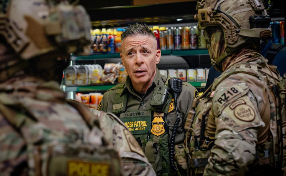 Gregory Bovino talks with other federal agents.