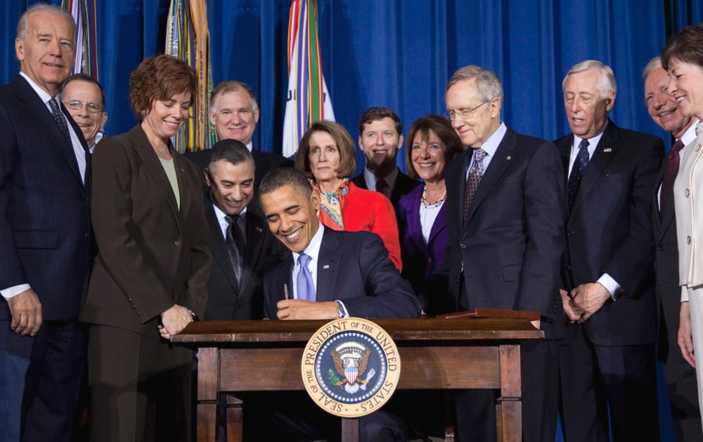 Lawmakers and supporters look on as President Barack Obama signs "don't ask, don't tell" repeal legislation that would allow gays to serve openly in the military, Wednesday, Dec. 22, 2010