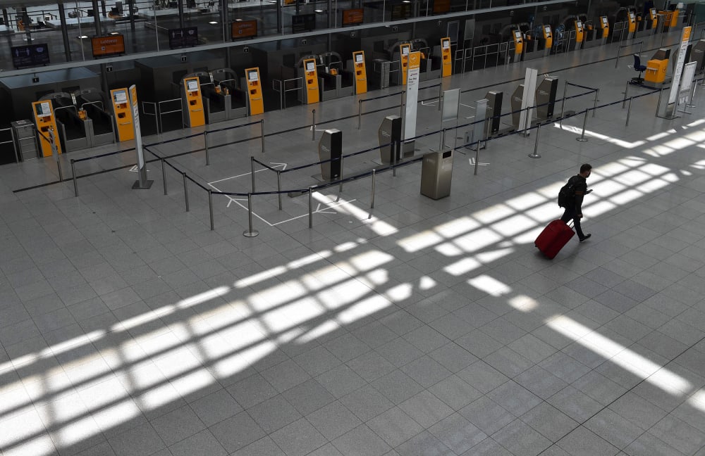 Image: A passenger walks in an empty terminal at the "Franz-Josef-Strauss" airport in Munich