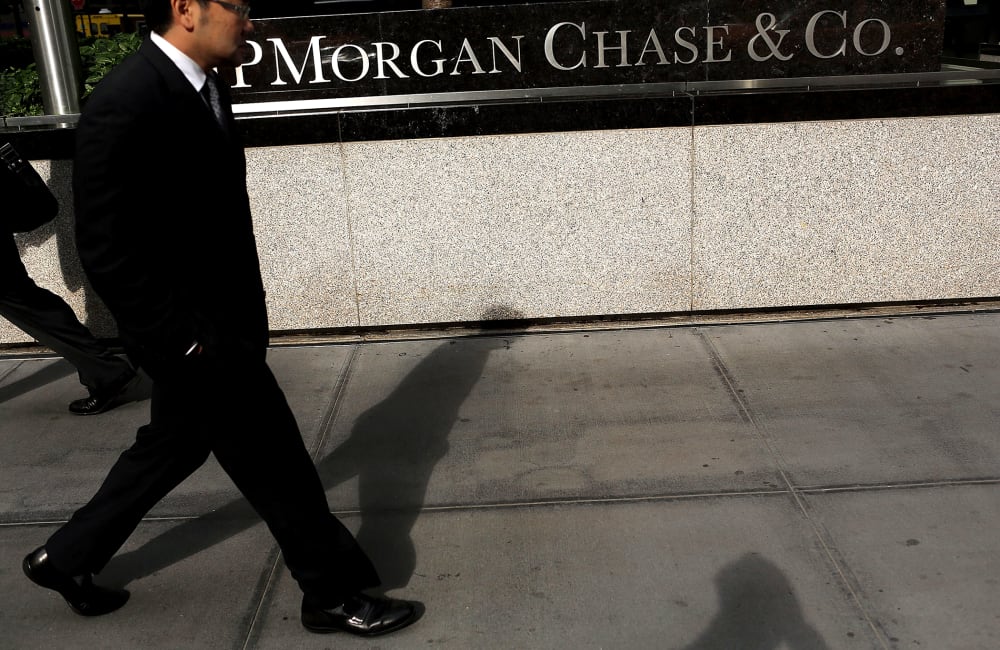 People pass a sign for JPMorgan Chase & Co. at it's headquarters in Manhattan on October 2, 2012 in New York City.