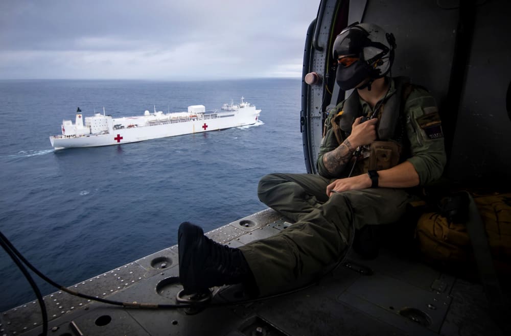 Image: A Naval aircrewman flies in a Seahawk helicopter alongside the USNS Comfort, a hospital ship, in the Pacific Ocean on on June 24, 2019.