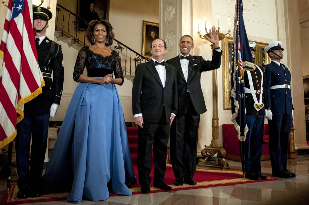 US President Barack Obama and First Lady Michelle Obama pose for a photo with President Francois Hollande of France on the Grand Staircase in the White House in Washington on Feb. 11, 2014.