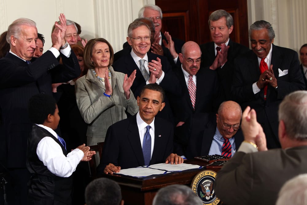 Image: President Barack Obama is applauded after signing the Affordable Care Act in the East Room of the White House on March 23, 2010.