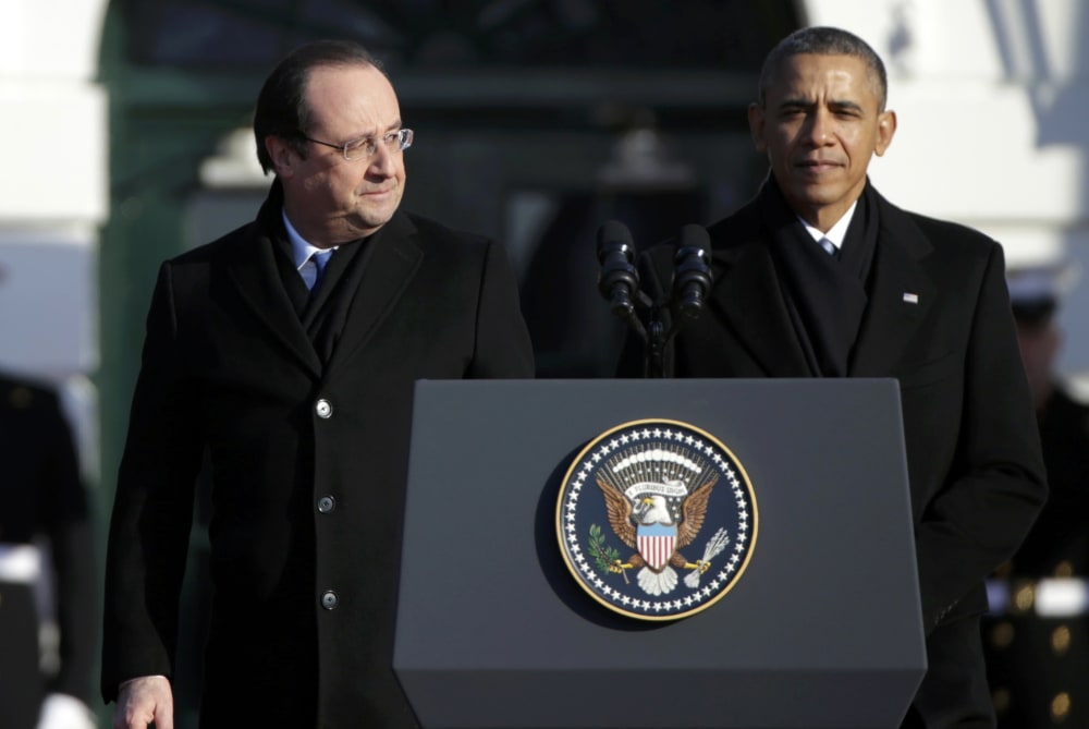 French President Francois Hollande (L) looks over at U.S. President Barack Obama during a State Arrival ceremony in Hollande's honor on the South Lawn of the White House in Washington, February 11, 2014.