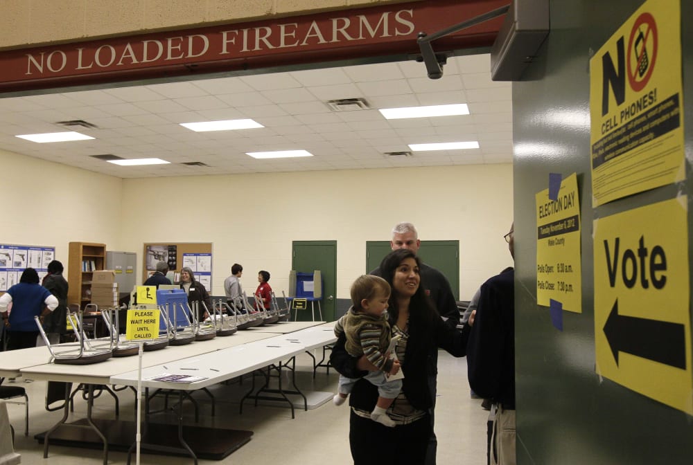 Melissa McBrien and son Tyler, 11 months, exit a polling precinct after voting at the Wake County Firearms Education and Training Center on Election Day in Apex, N.C., Tuesday, Nov. 6, 2012. (AP Photo/Gerry Broome)