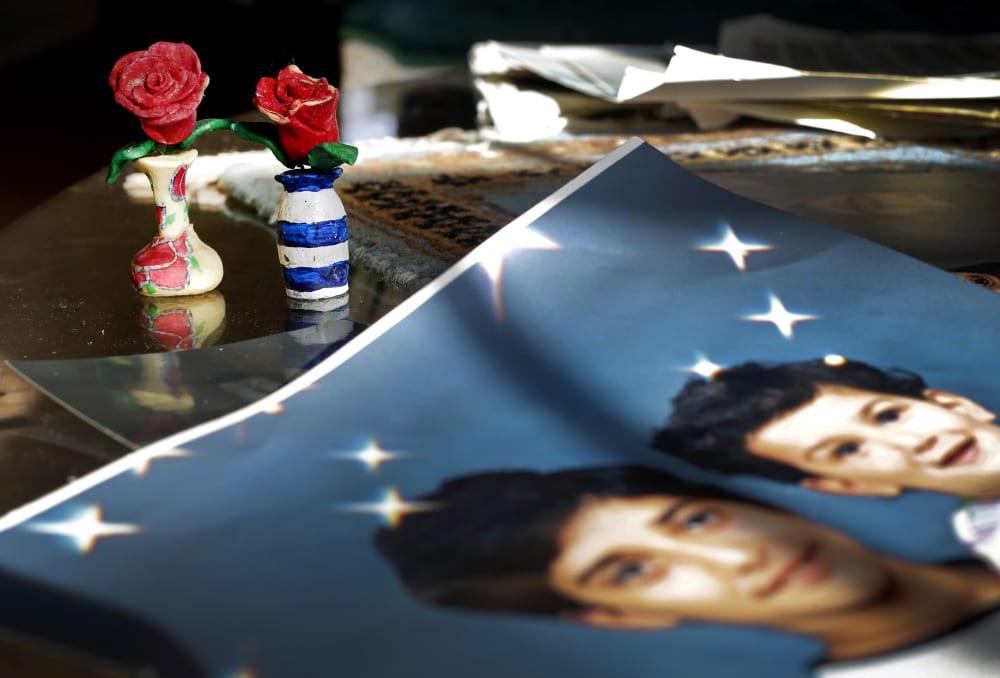 In this Dec. 10, 2014 photo, Prison artwork created by Adnan Syed sits near family photos in the home of his mother, Shamim Syed, in Baltimore, Md. (Photo by Patrick Semansky/AP)