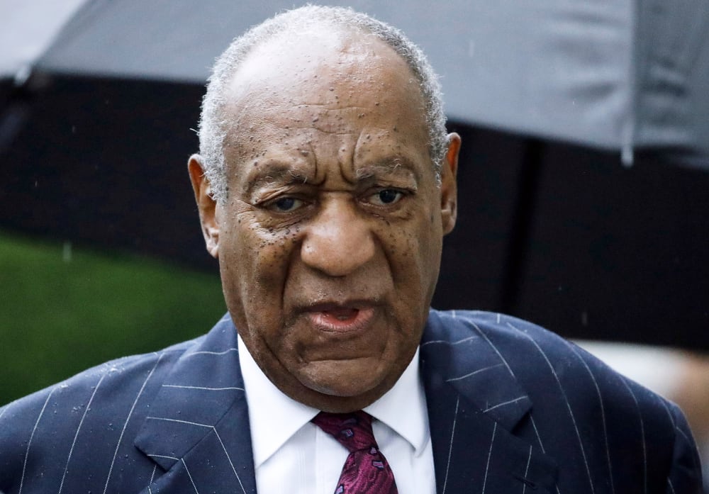 A close up of Bill Cosby looking upset in the rain.