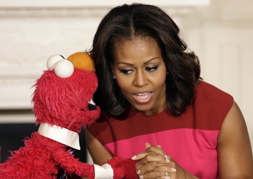 U.S. first lady Michelle Obama listens to Sesame Street character Elmo after delivering remarks on marketing healthier foods to children at the White House, October 30, 2013.