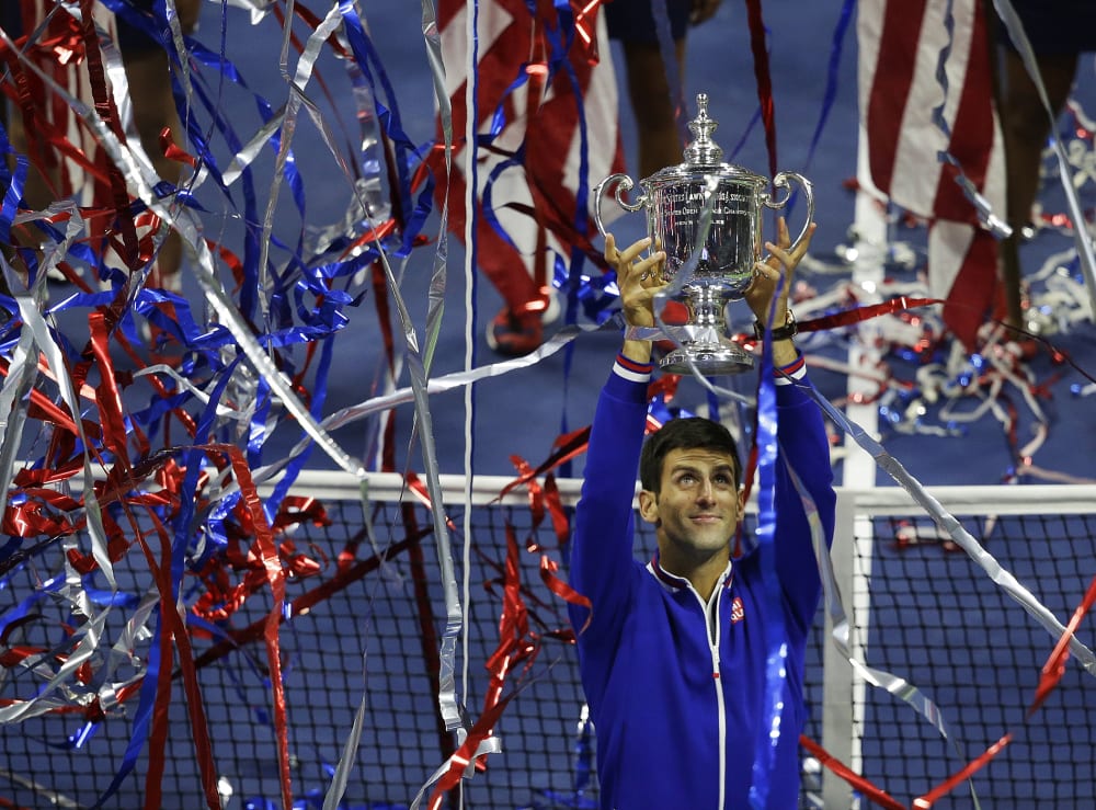 Novak Djokovic, of Serbia, holds up the championship trophy after defeating Roger Federer, of Switzerland, in the men's championship match of the U.S. Open tennis tournament, Sep. 13, 2015, in New York. (Photo by Seth Wenig/AP)