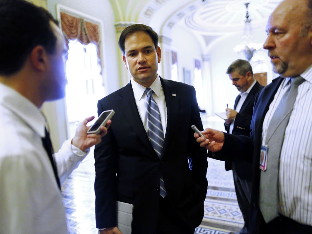 U.S. Senator Marco Rubio talks to reporters on his way to vote on the Senate floor at the U.S. Capitol in Washington, October 12, 2013.