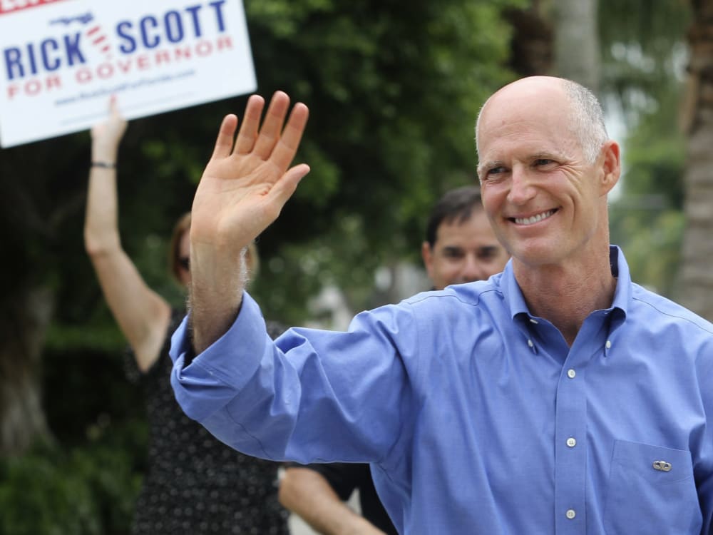 File Photo: Florida Republican Gubernatorial candidate Rick Scott greets supporters near his precinct Tuesday Aug. 24, 2010, in Naples, Fla. (Photo by Erik Kellar/AP Photo/File)