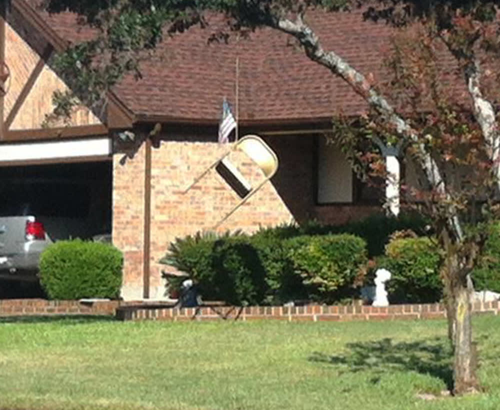A folding chair and an American flag hang from a tree in front of a home in northwest Austin, Texas.