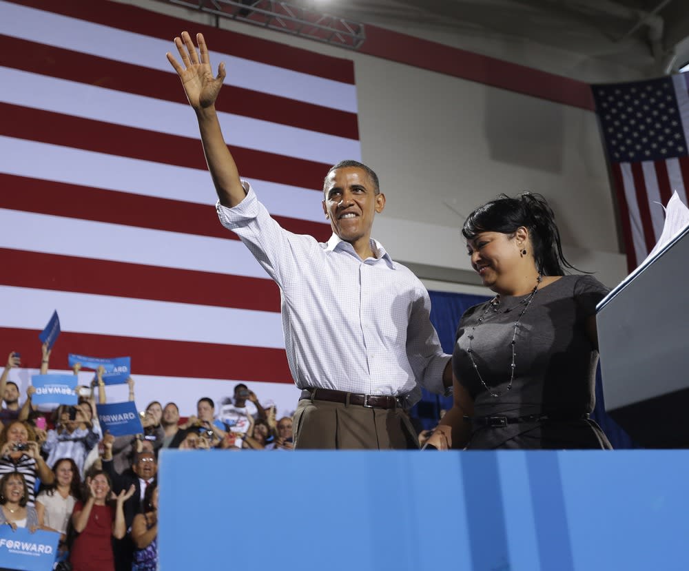 President Barack Obama, left, on stage after being introduced by Viviana Margarita Janer, right, at a campaign event Saturday at the Kissimmee, Fla., Civic Center.