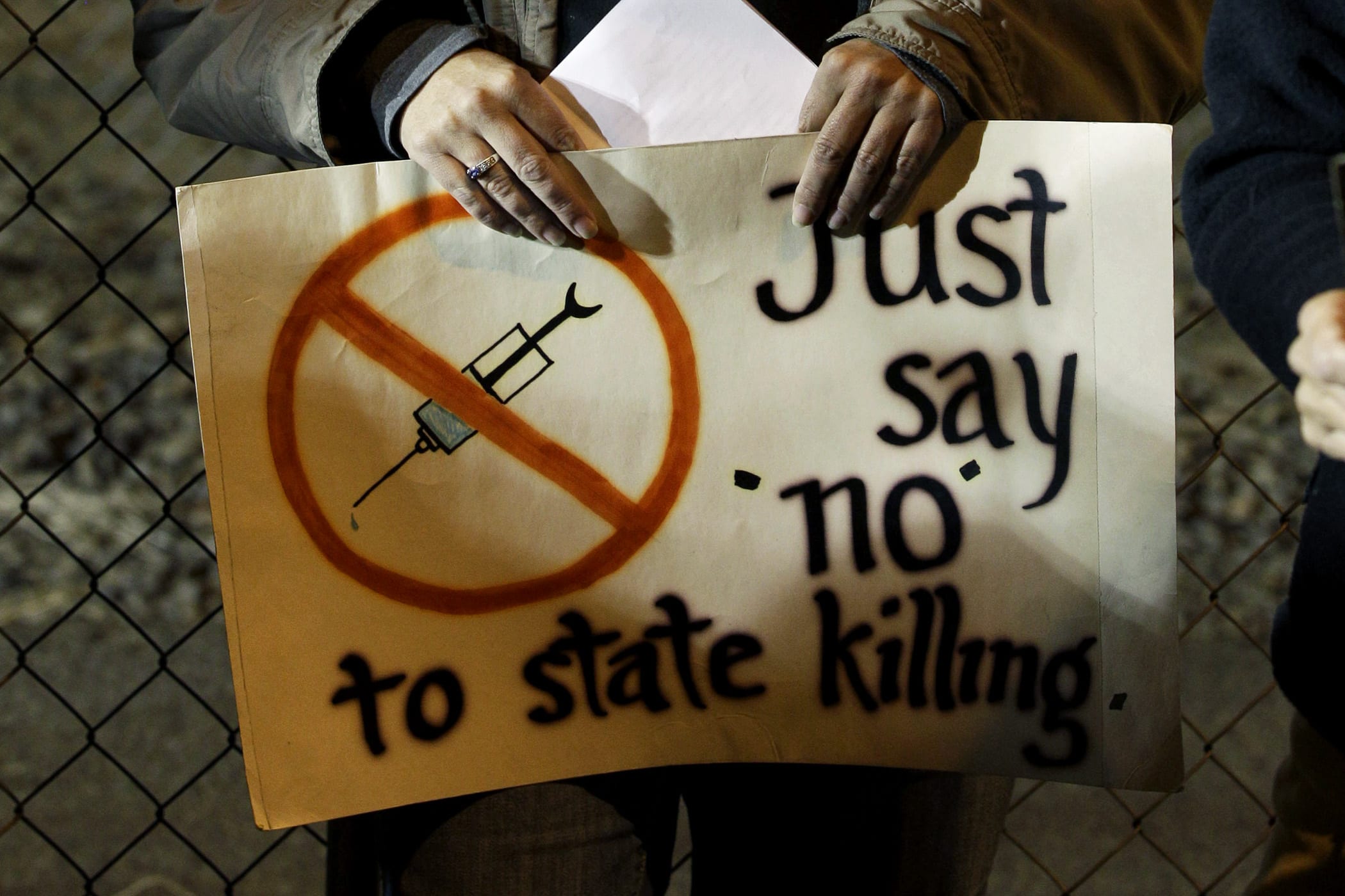 A woman holds a sign outside the Washington State Penitentiary, in Walla Walla, Wash, Sept. 9, 2010.