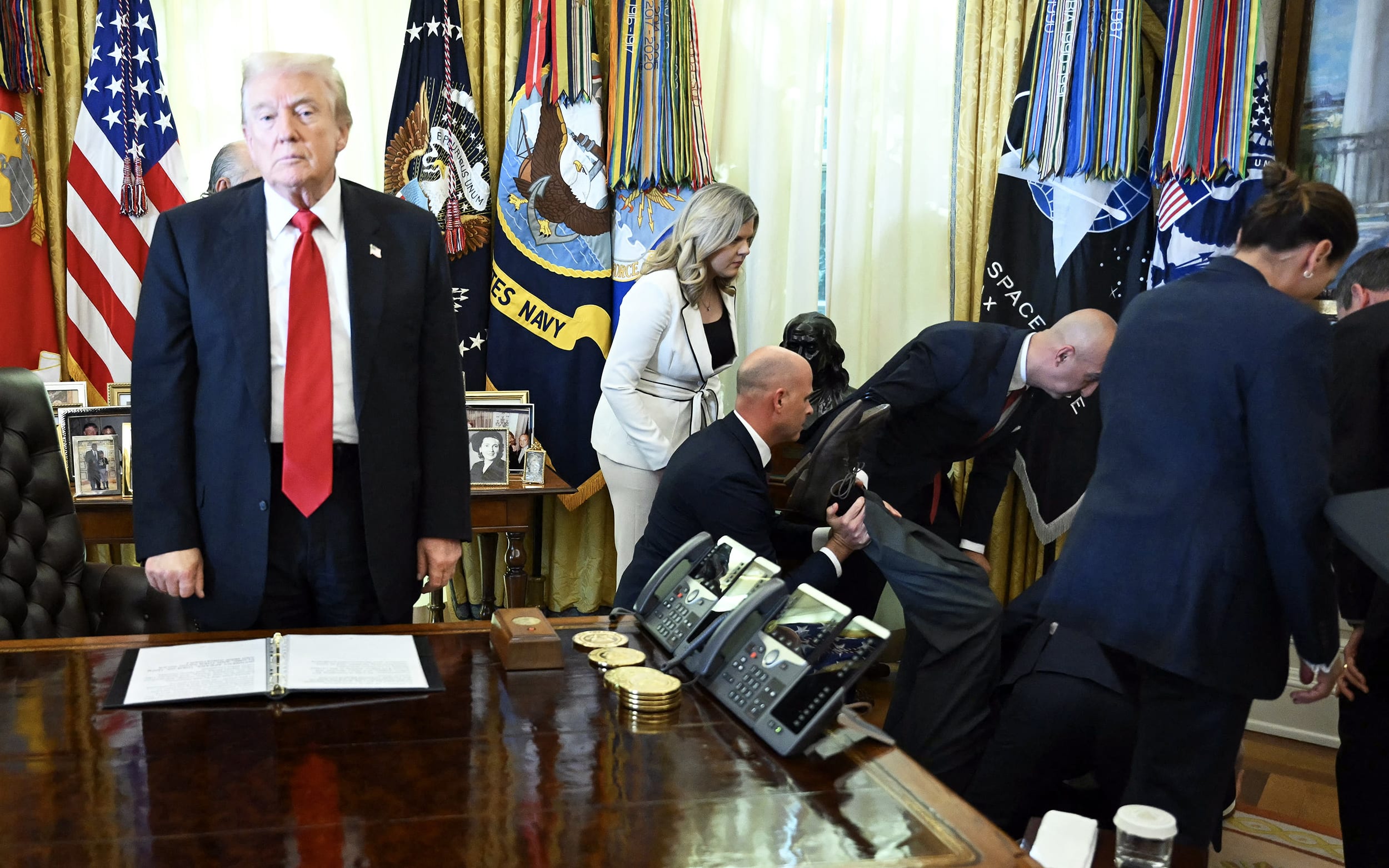 US President Donald Trump looks on after a man fainted during an announcement in the Oval Office.