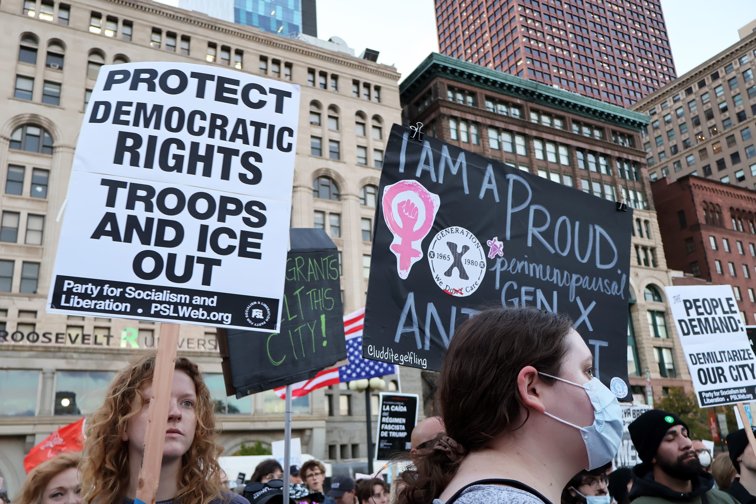 Anti-ICE protesters holding up signs in Chicago.