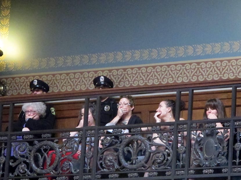 Opponents of a series of Republican-backed bills dealing with abortions hold their hands over their mouths while watching debate in the state Assembly on Thursday, June 13, 2013, in Madison, Wis. (Photo by Scott Bauer/AP)