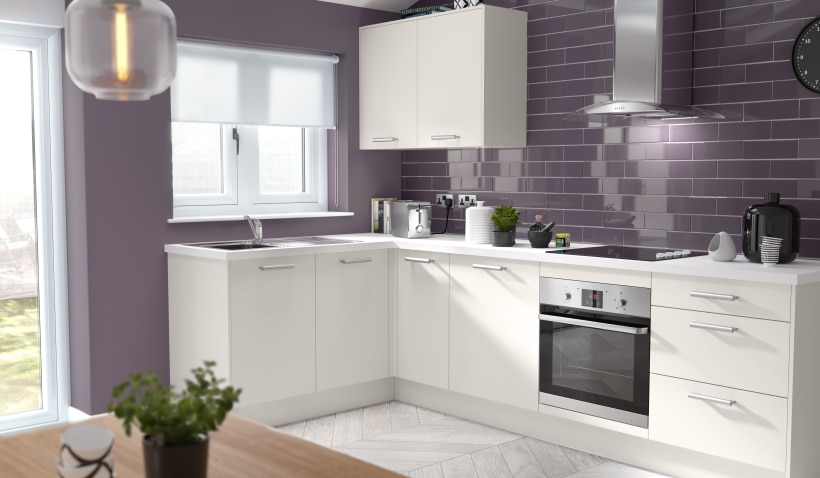 Hero shot of the L-shaped open plan Slab Kitchen in Light Grey with integrated appliances, emily bar handles and herringbone flooring