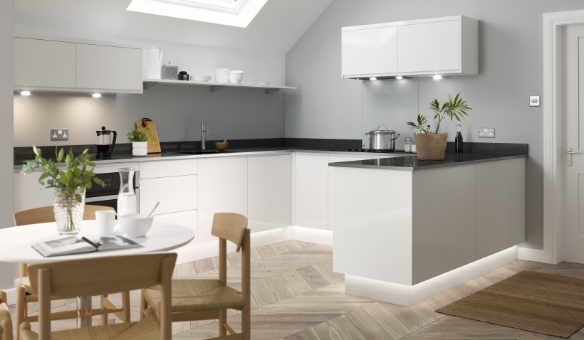 Hero shot of the U-shaped J Pull Kitchen in White Gloss featuring dining table and herringbone flooring