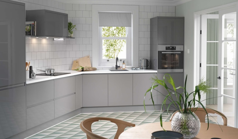 Hero shot of the J Pull Kitchen in Lava Grey with dining table and integrated appliances