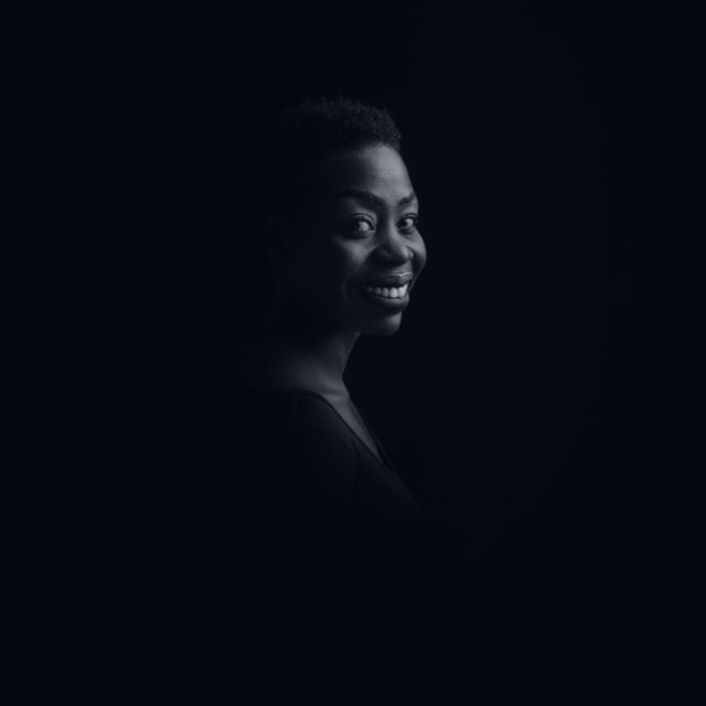 Low-key studio portrait of a smiling woman