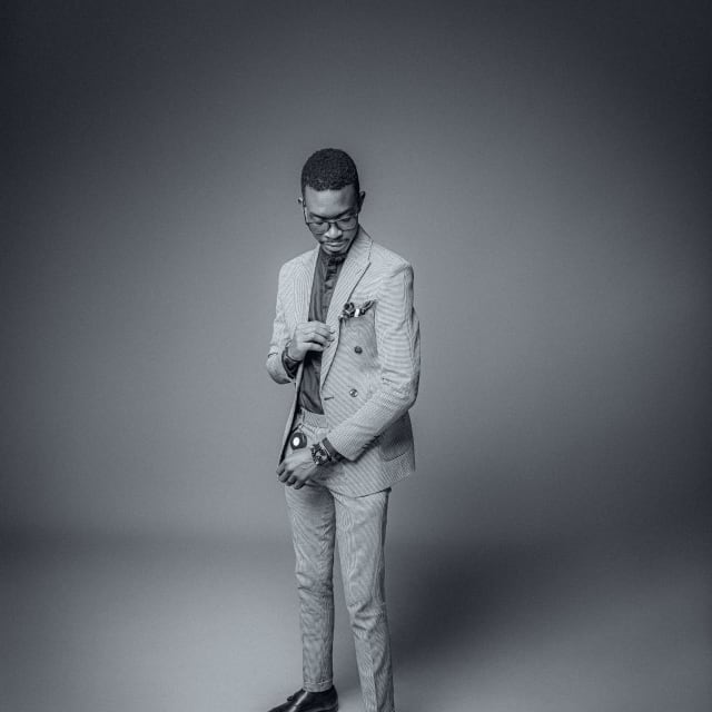 Full-length studio portrait of a man in a light suit