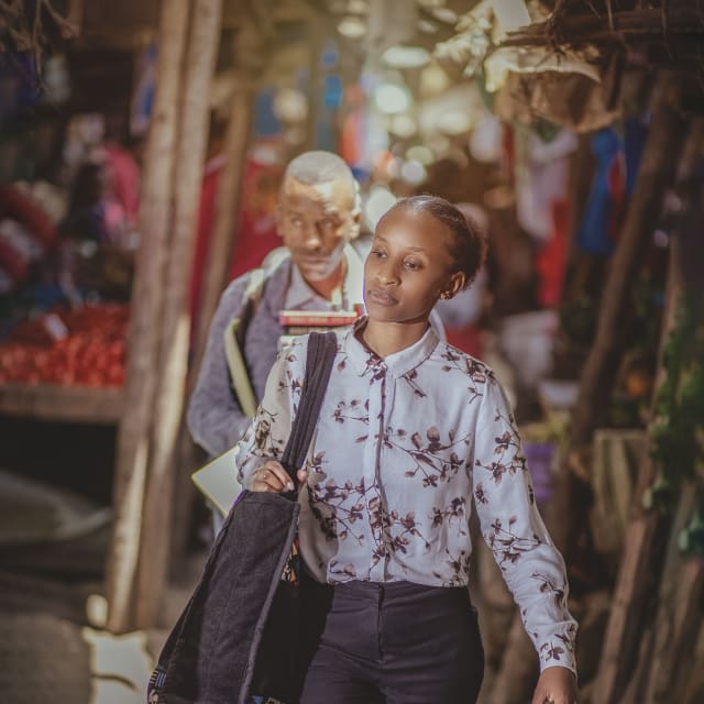 A young woman walking through an outdoor market