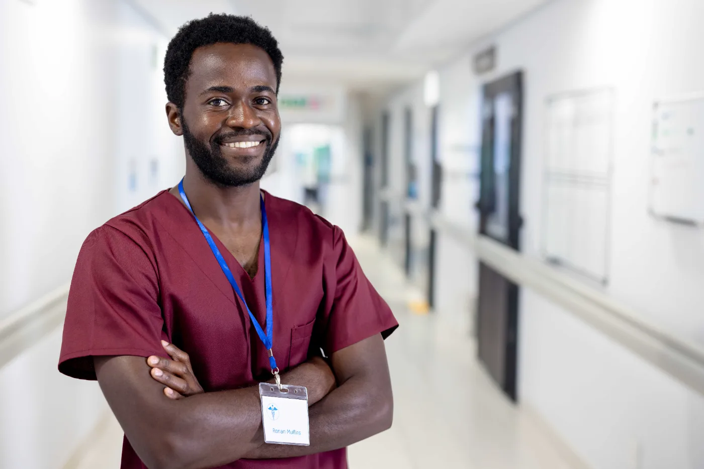 A smiling clinician in a hospital corridor