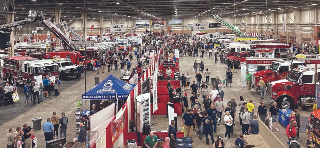 The exhibition hall at Fire Expo showcasing many different fire trucks.
