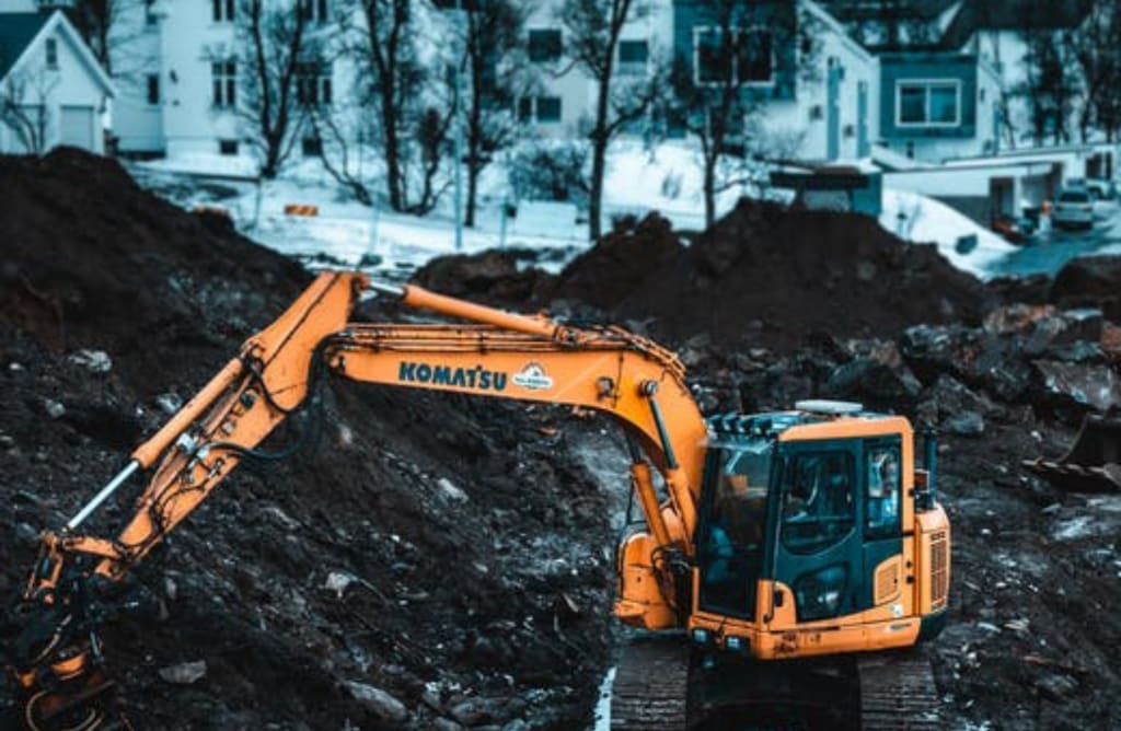 Small full-sized excavator in operation during winter.