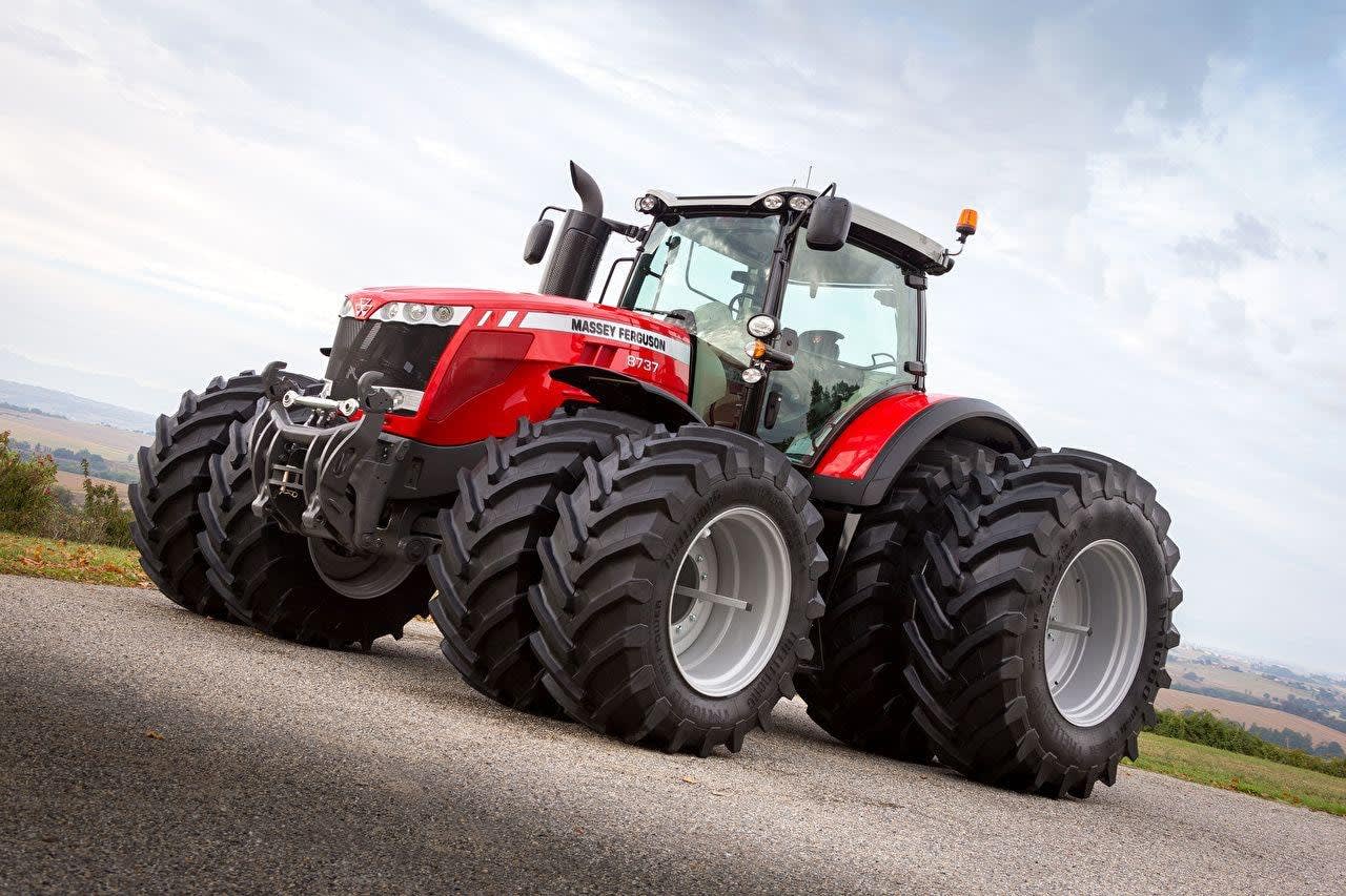 Massey Ferguson 8737, part of the MF 8700 series, parked on pavement with a field in the background.