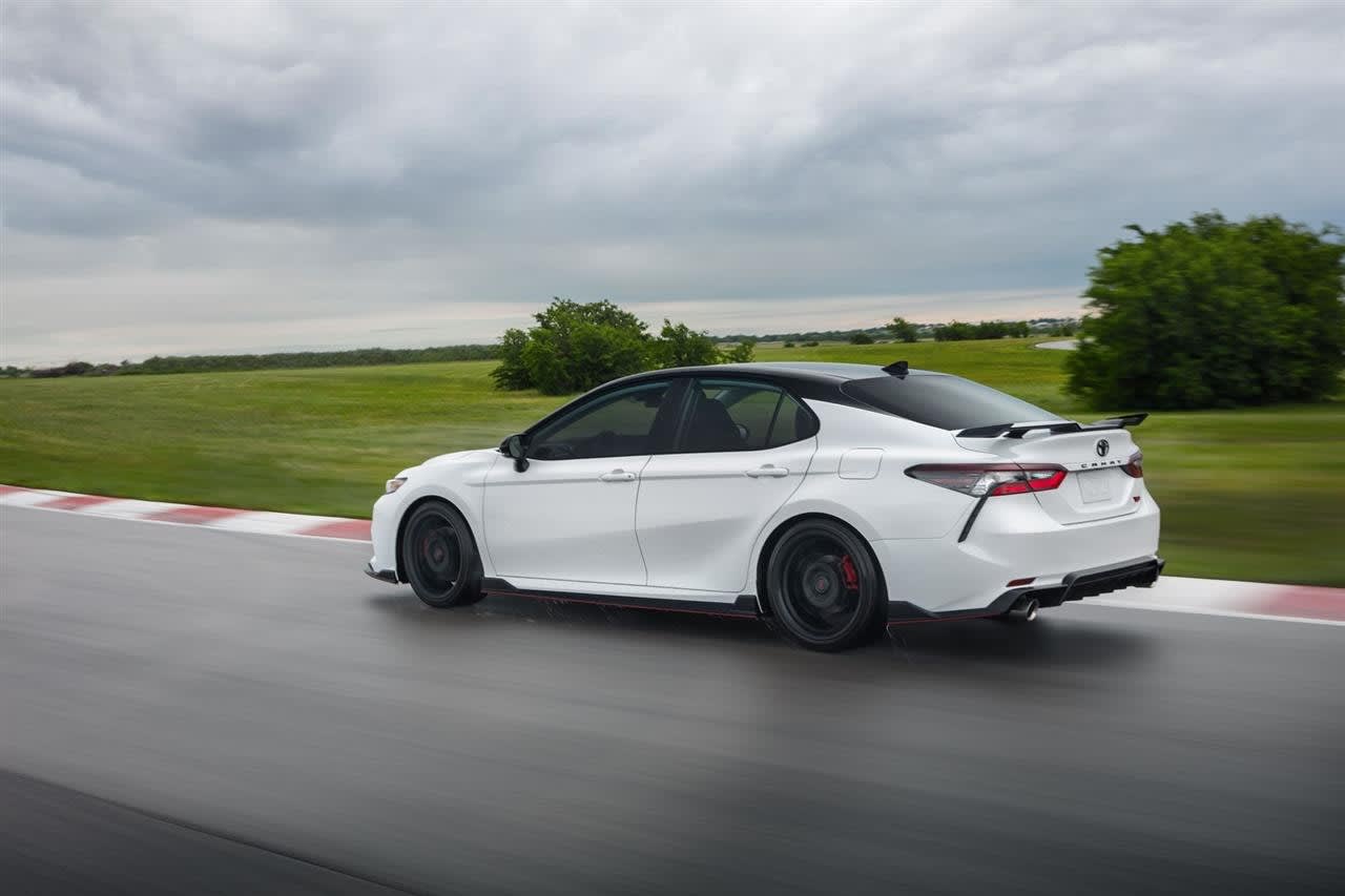 2024 Toyota Camry car (Camry hybrid version), with low miles, driving on a road.