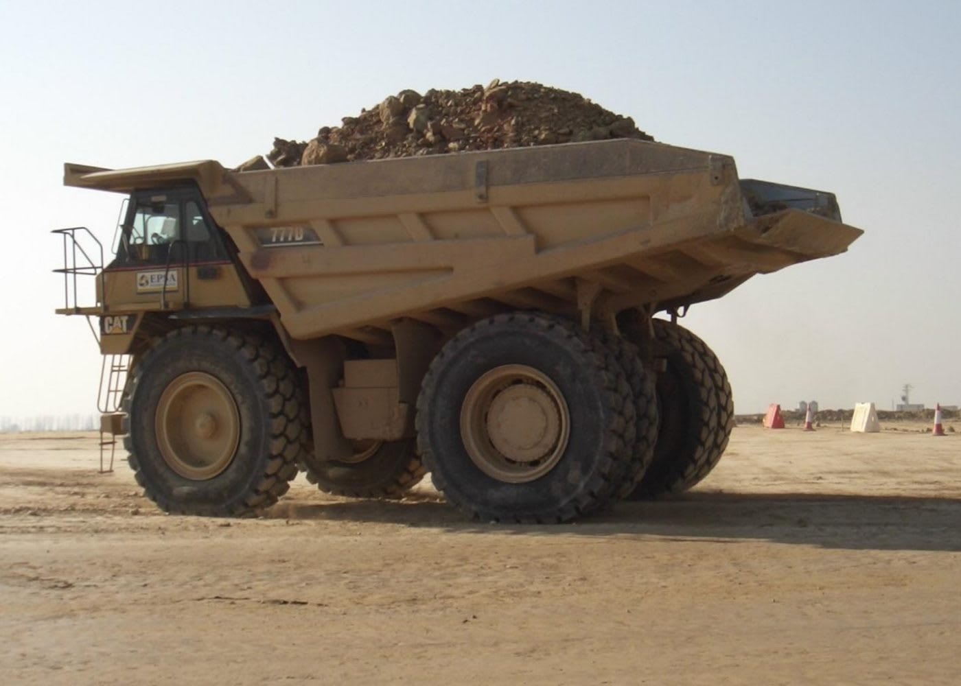 Brown rigid haul truck towing a load of minerals
