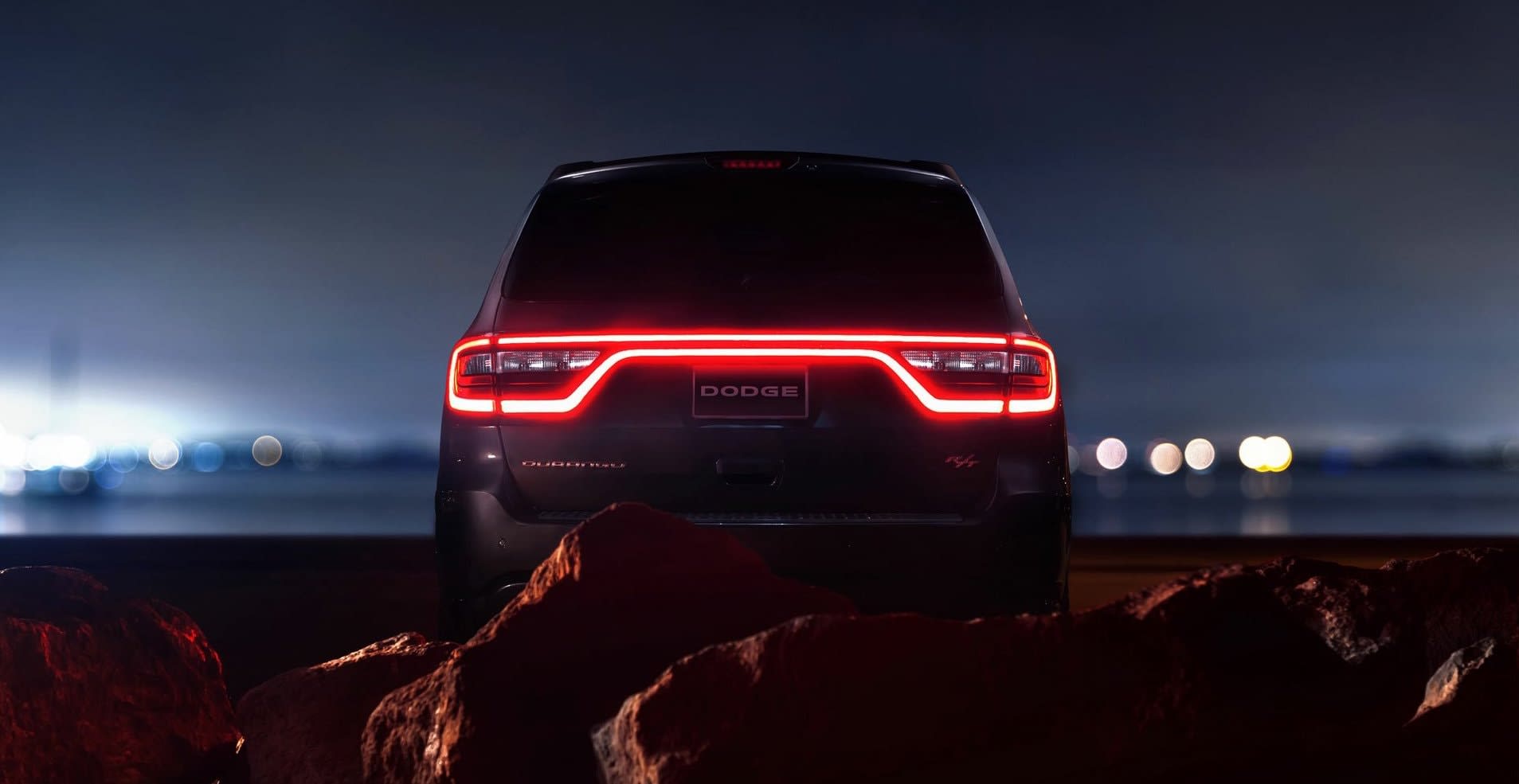 Dodge Durango parked at night with lights in the distance.